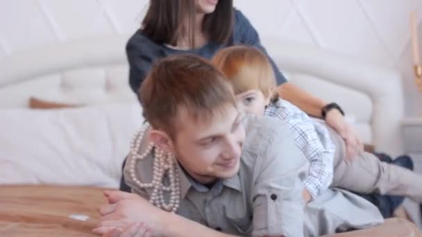 Parents avec un enfant assis sur le lit — Video