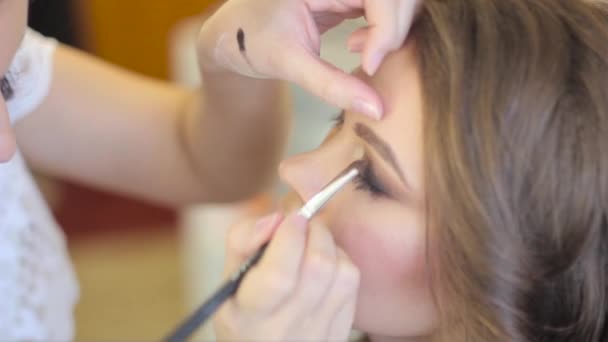 Maquillaje artista pinta los ojos — Vídeo de stock