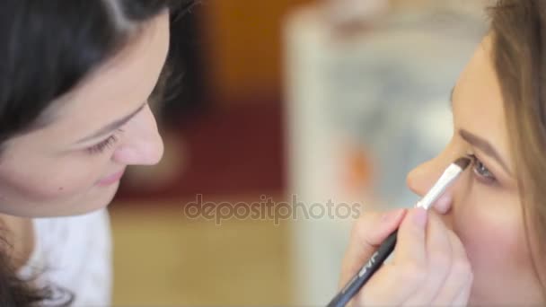 Maquillaje artista pinta los ojos — Vídeo de stock