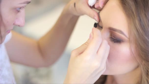 Maquillaje artista pinta los ojos — Vídeo de stock