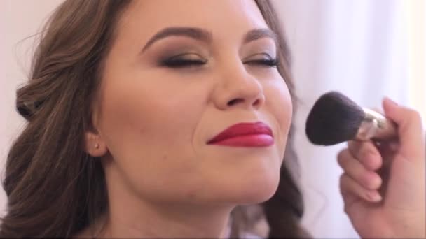 Een make-up artiest poeders het gezicht — Stockvideo