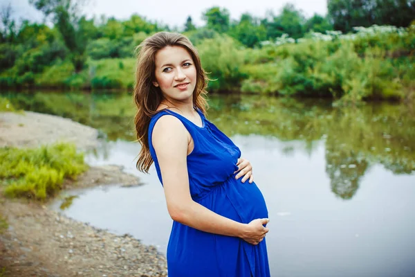 Těhotná žena poblíž vody — Stock fotografie