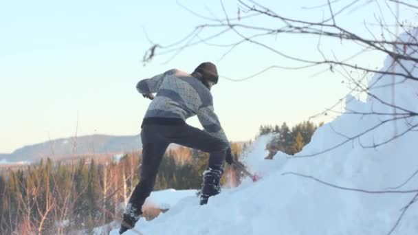 Hombre quitando nieve del techo con una pala — Vídeos de Stock