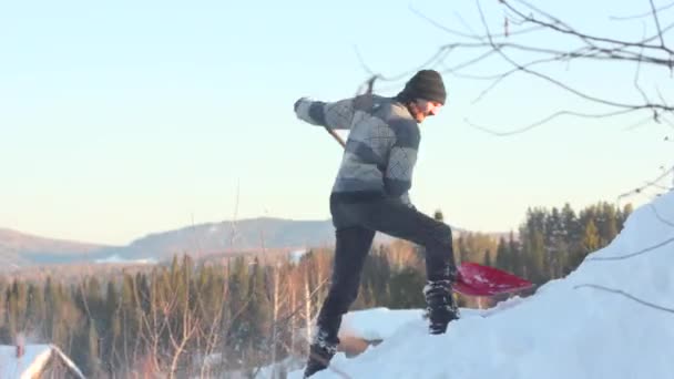 Mannen att ta bort snö från taket med en spade — Stockvideo