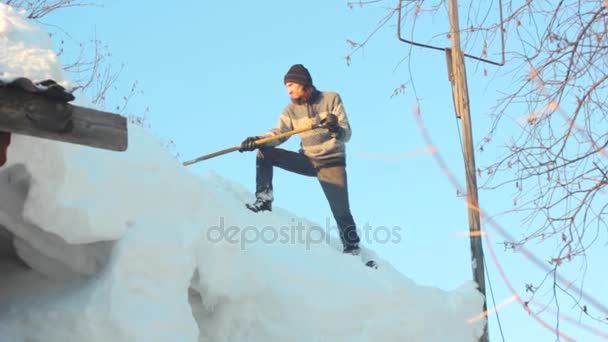 Homem removendo neve do telhado com uma pá — Vídeo de Stock