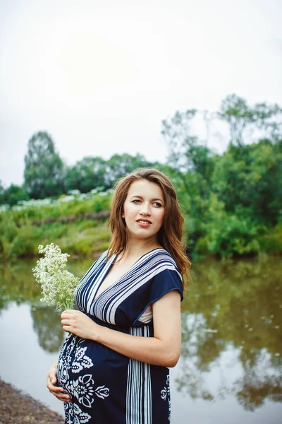 Zwangere vrouw in de buurt van het water — Stockfoto