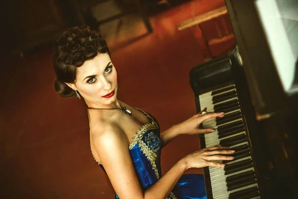 Κορίτσι με ένα φόρεμα στο πιάνο — Φωτογραφία Αρχείου