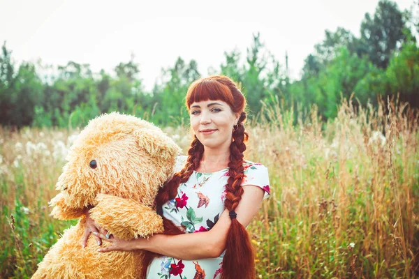 Žena s plyšovým medvědem v přírodě — Stock fotografie