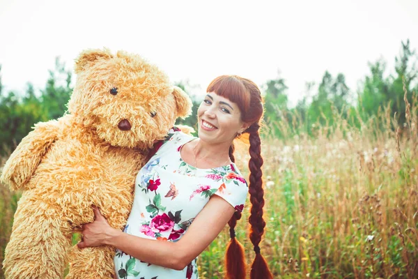 Žena s plyšovým medvědem v přírodě — Stock fotografie