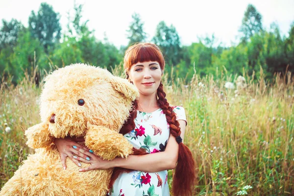 Vrouw met een teddybeer in de natuur — Stockfoto