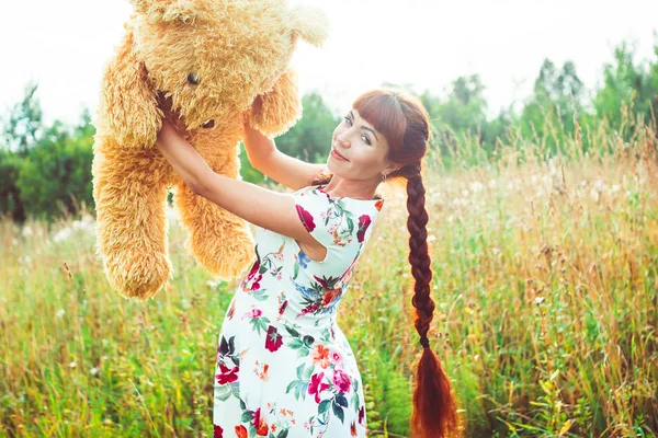 Frau mit Teddybär in der Natur — Stockfoto