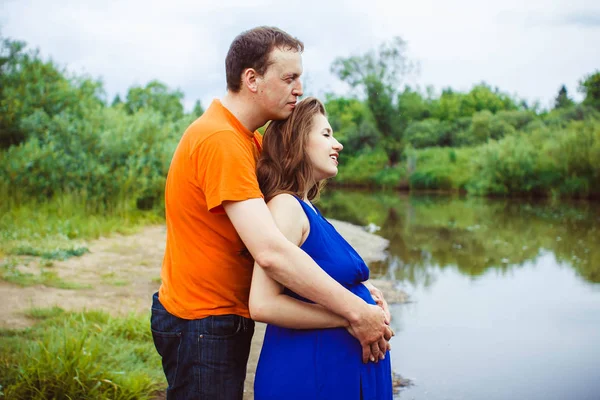 A guy and a pregnant woman near the water — Stock Photo, Image