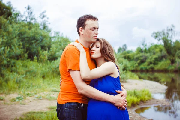 Ένας άντρας και μια έγκυος γυναίκα κοντά στο νερό — Φωτογραφία Αρχείου