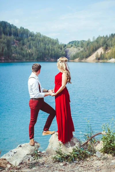 Coppia in piedi vicino ad un lago in un abbraccio — Foto Stock