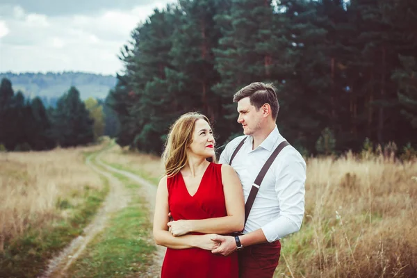 Os amantes estão de pé em uma estrada florestal — Fotografia de Stock