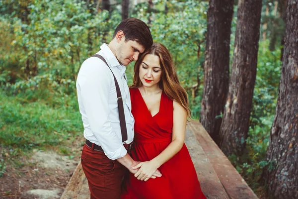 Casal amoroso na floresta no banco — Fotografia de Stock