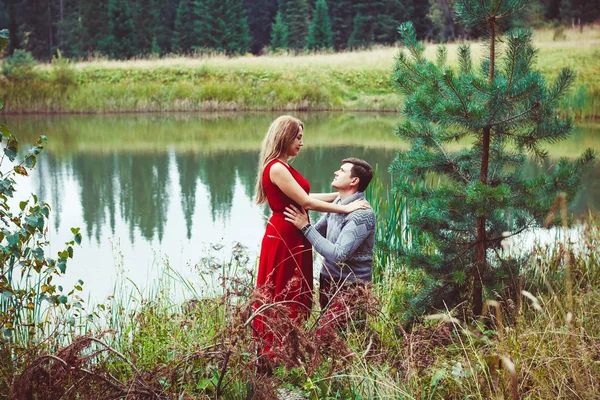 The couple is sitting by the lake — Stock Photo, Image