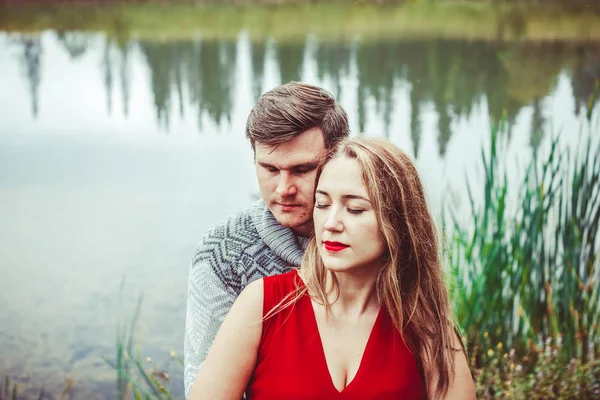 O casal está sentado junto ao lago. — Fotografia de Stock