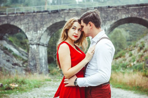 Lovers are standing by the bridge — Stock Photo, Image