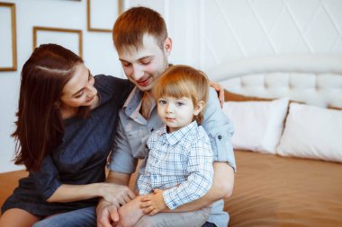 yatakta oyuncaklarla oynayan bir çocuk ile anne