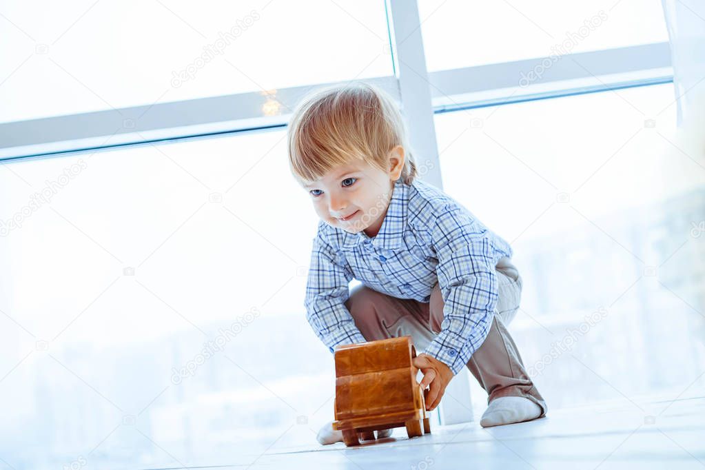 Boy rolls a toy car