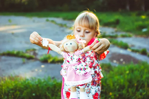 Girl with a doll in the nature — Stock Photo, Image