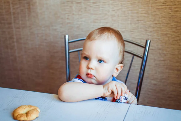 A gyermek az asztalnál eszik édességet — Stock Fotó