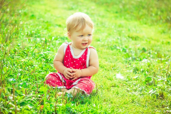 A criança está sentada na grama — Fotografia de Stock