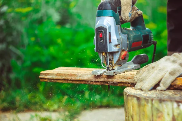 Elektrikli testere kullanarak koruma eldivenli adam