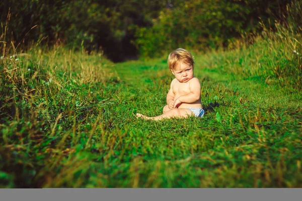那孩子正坐在草地上 — 图库照片