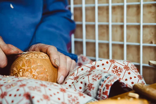 a craftsman carves wood