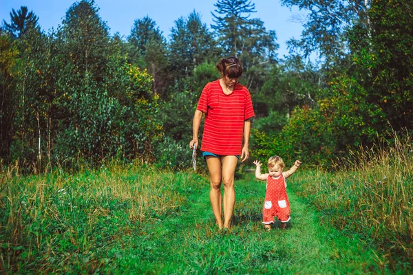 A criança aprende a andar na grama — Fotografia de Stock