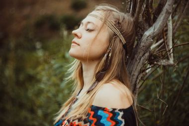 kıza karşı bir ağaca doğru eğildi.