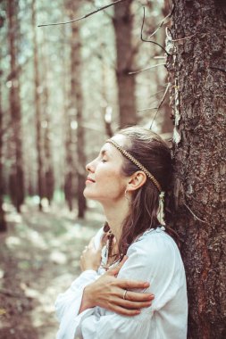 Bir kadın ağaçlar arasında duruyor