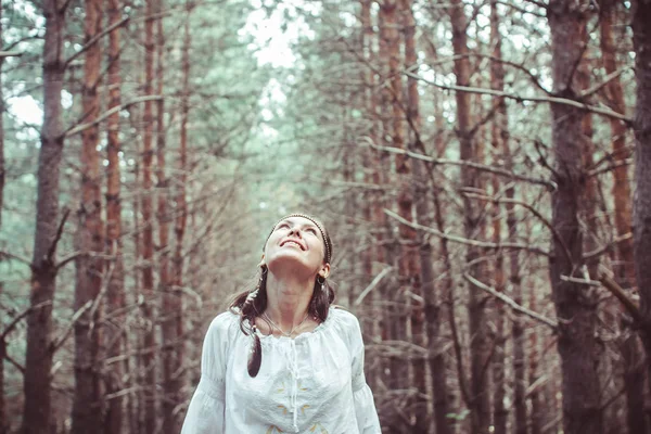 Bir kadın ağaçlar arasında duruyor