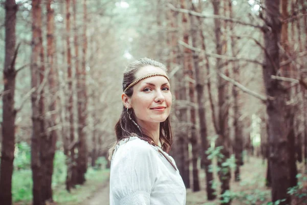 Bir kadın ağaçlar arasında duruyor