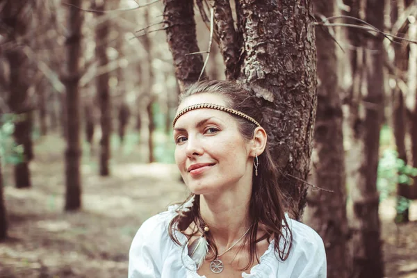 Bir kadın ağaçlar arasında duruyor