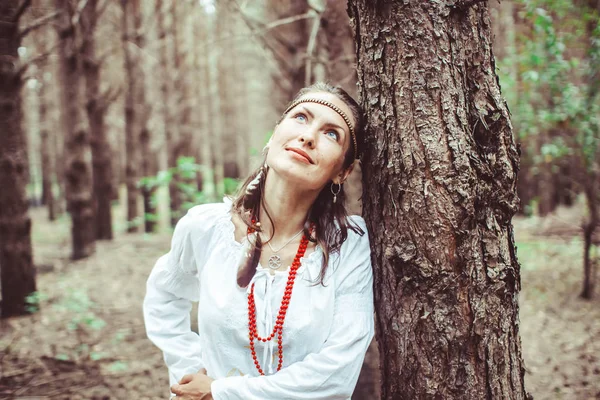 Bir kadın ağaçlar arasında duruyor