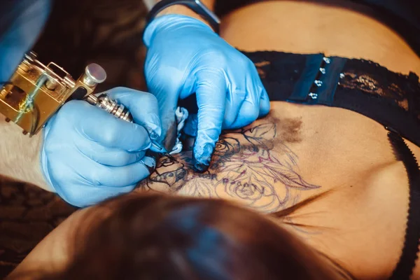 Master tattoo woman on her back — Stock Photo, Image