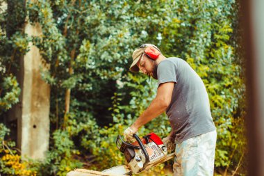 bir adam bir günlük bir testere ile kesme