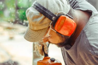 bir adam bir günlük bir testere ile kesme