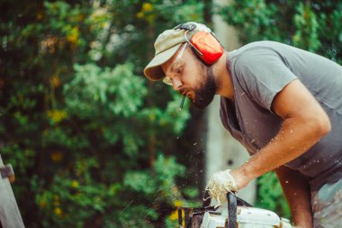 bir adam bir günlük bir testere ile kesme