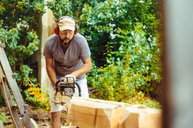 bir adam bir günlük bir testere ile kesme