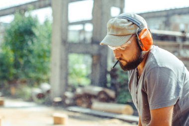 bir adam bir günlük bir testere ile kesme