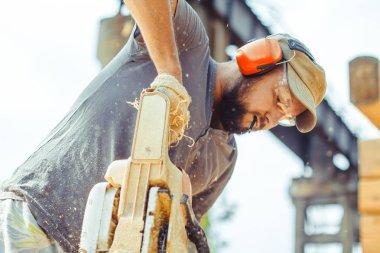 bir adam bir günlük bir testere ile kesme