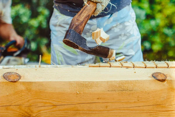 Een man snijdt een logboek — Stockfoto