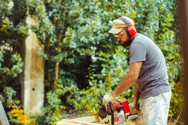 bir adam bir günlük bir testere ile kesme