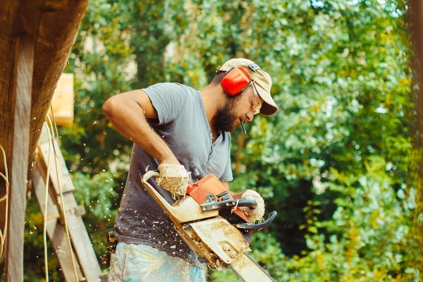 bir adam bir günlük bir testere ile kesme