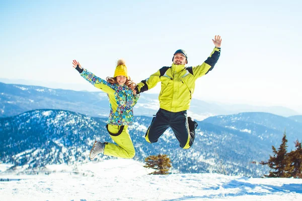Paar springt im Winter in den Bergen — Stockfoto