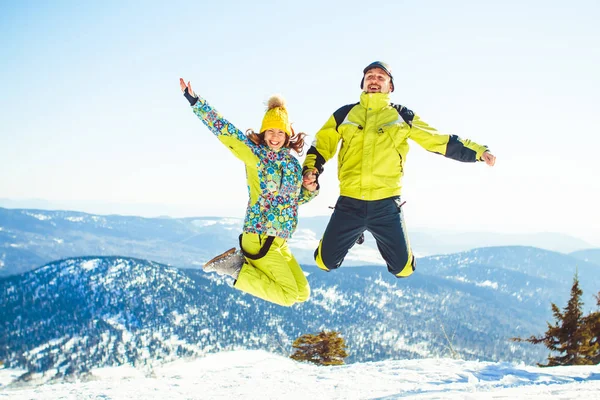 Paar springt im Winter in den Bergen — Stockfoto